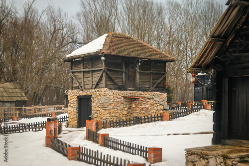 Old idyllic houses in small retro village. Snow melting, sunset, ethno village Moravski Konaci, near the Velika Plana in Serbia. photo