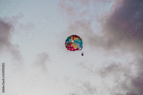 Parasailing in evening. Bright parachute on a background of a sunset