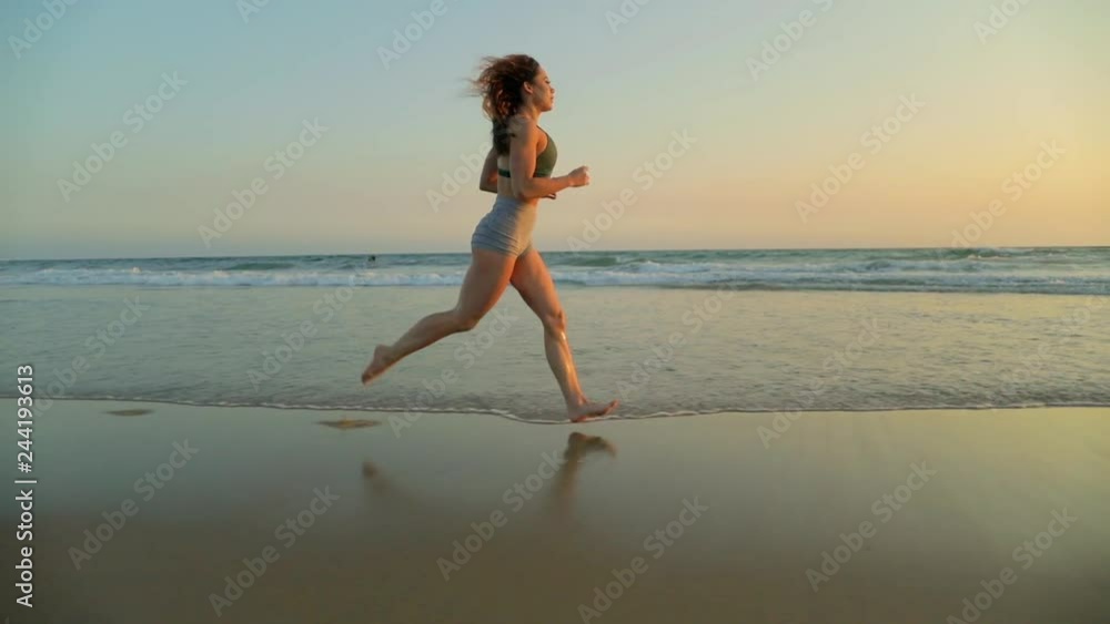 Very fit woman working out on the beach at sunset. Very fit woman working out on the beach at sunset.