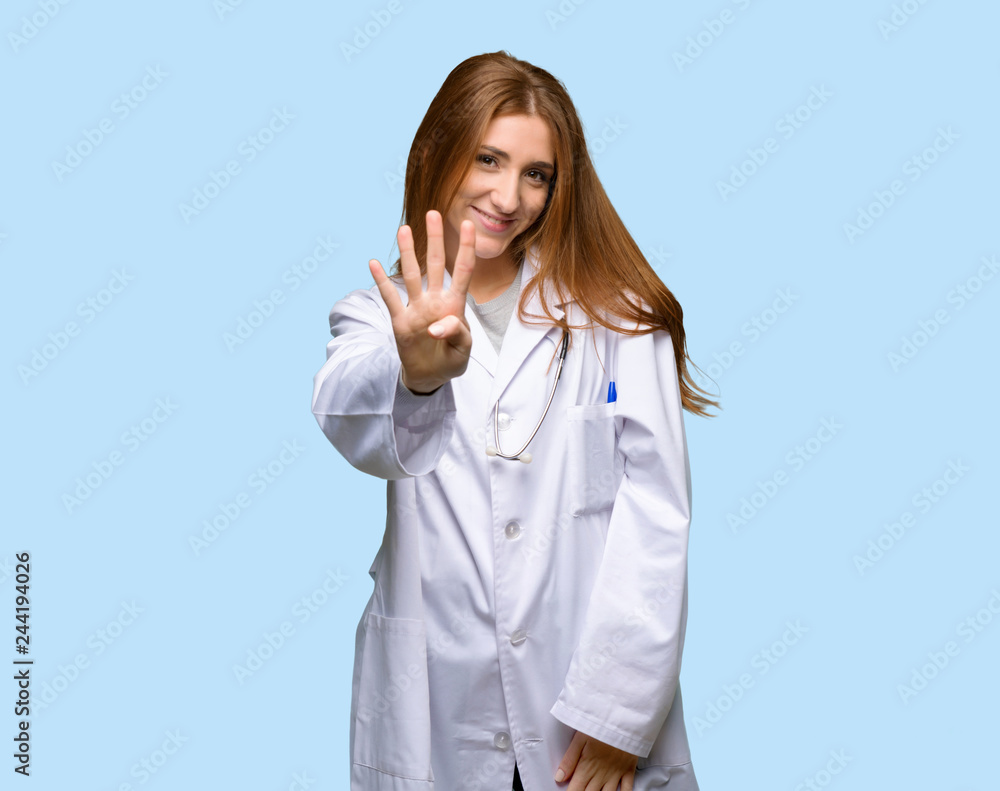 Redhead doctor woman happy and counting four with fingers on isolated blue background Redhead doctor woman happy and counting four with fingers on isolated blue background