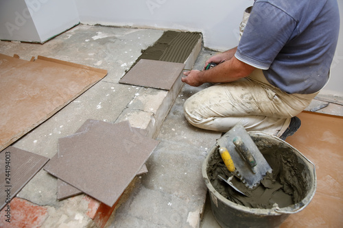  The builder arranges ceramic tiles on the stairs inside the building.