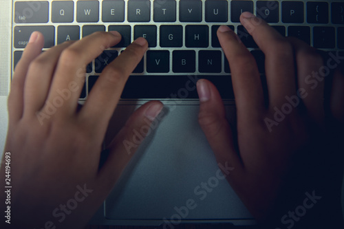 Using the finger to touch the keyboard of the notebook. - Images