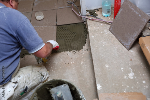  The builder arranges ceramic tiles on the stairs inside the building.