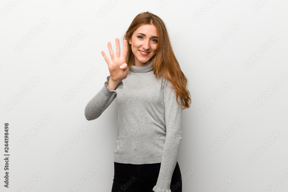 Redhead girl over white wall happy and counting four with fingers Redhead girl over white wall happy and counting four with fingers