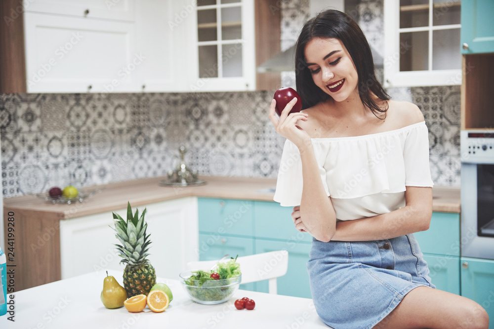 Beautiful woman with healthy food fruit in the kitchen. Beautiful woman with healthy food fruit in the kitchen.