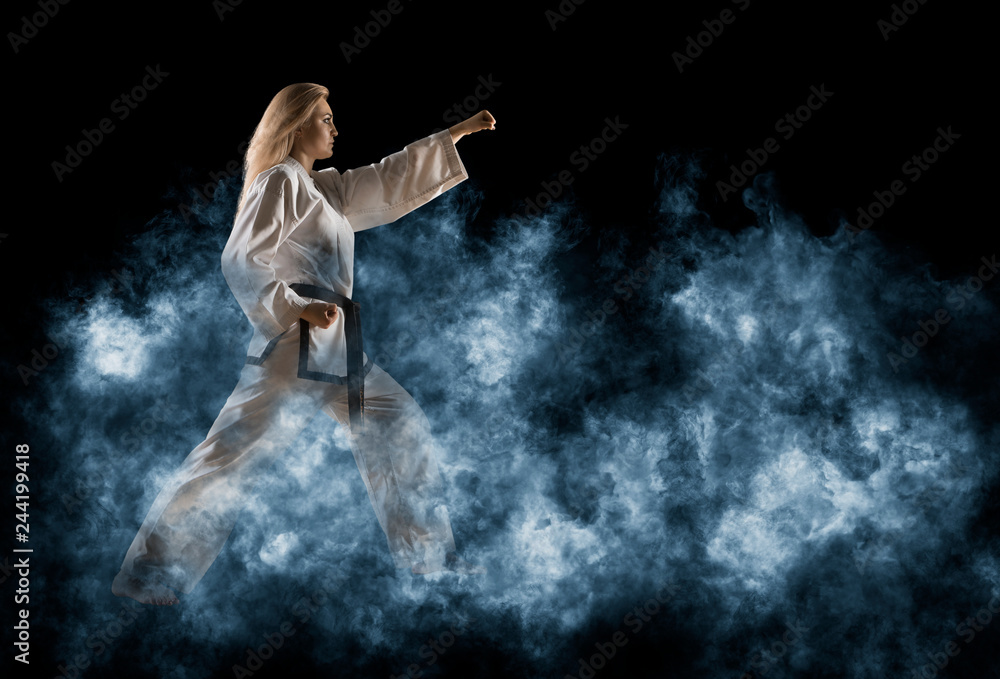 Woman in kimono practicing taekwondo