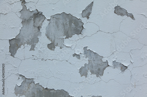 peeling white paint on a gray concrete wall