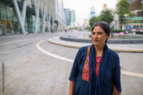 Mature beautiful Indian woman thinking in city © Ranta Images
