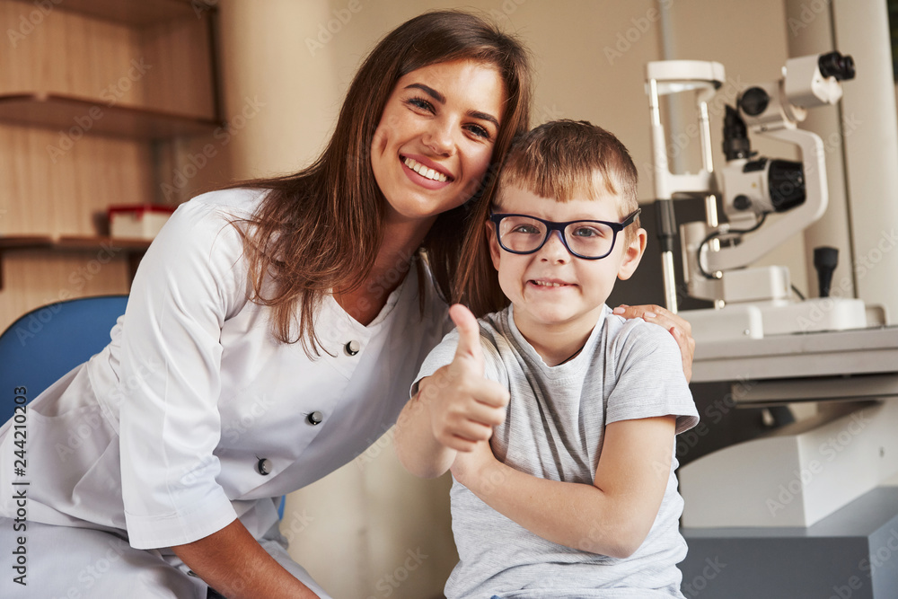 Ταπετσαρία Female eye doctor sitting with the kid after doing the vision test