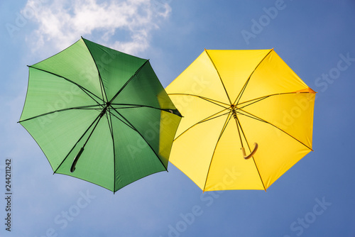 Gr  ner und gelber Regenschirm im Himmel