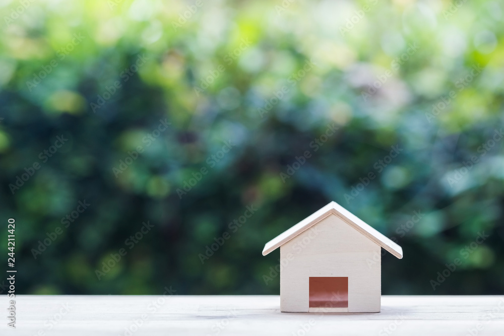 Home loan. Mortgage concepts Small wooden resident craft on table with green nature background. Home loan. Mortgage concepts Small wooden resident craft on table with green nature background.