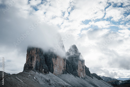 Little pieces of snow on the rocks. Mountains in the fog and clouds. Tre Cime di Lavaredo