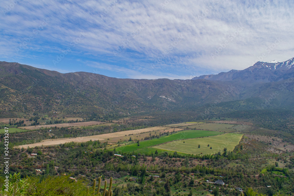 view of the valley between the mountains. view from above. to a residential valley. around the chilean mountains. below the village and ponds