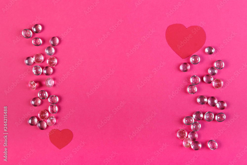 Frame made of white beads and paper red hearts on a pink background.