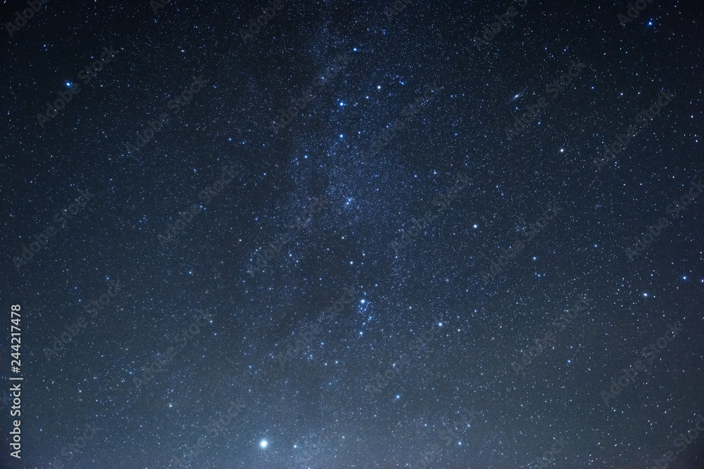 Fototapeta premium Milky way at center. Photo of beautiful blue night sky filled with stars