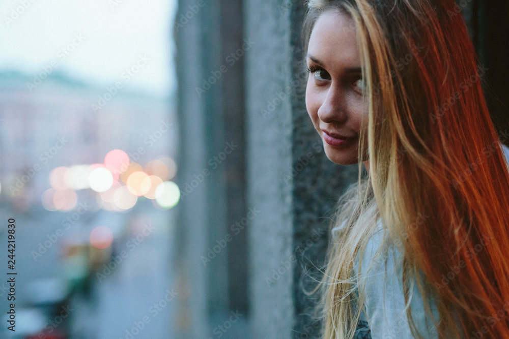 Beautiful blond girl posing for photo in the window frame