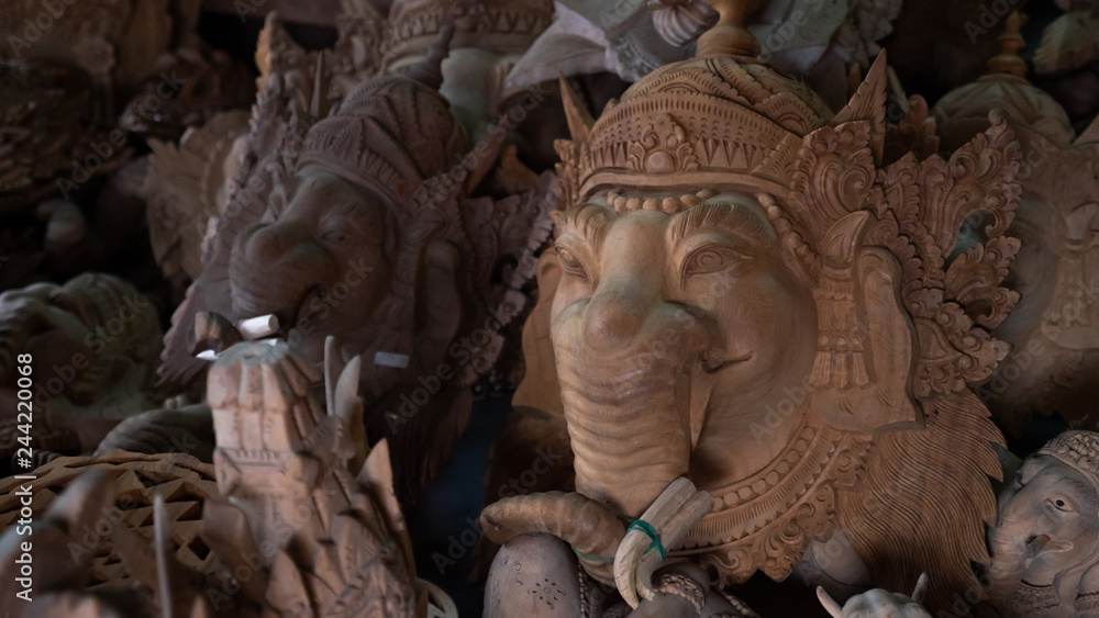 Fototapeta premium Hindu and Buddhist wooden carving. souvenir shop selling souvenirs and handicrafts of Bali at famous Ubud Market, Indonesia