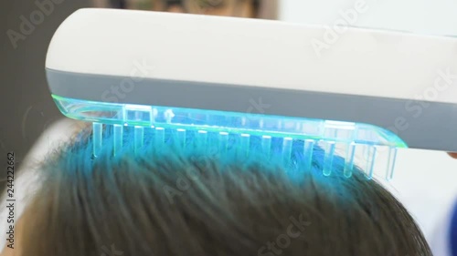 doctor dermatologist performs the procedure of ultraviolet comb to cure psoriasis. Phototherapy, light therapy