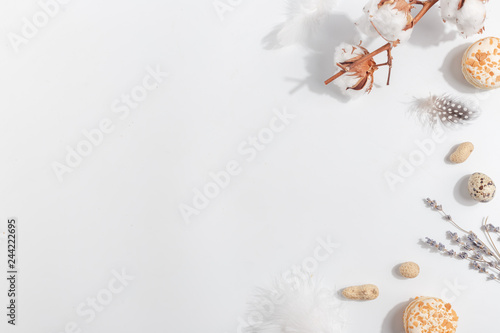 Cotton, lavender, cakes and nuts on a light background. Top view.