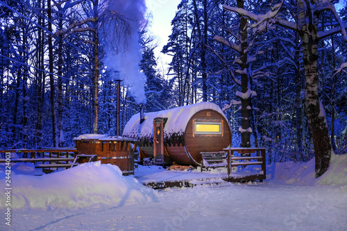 round wooden bath in the winter snowy forest at night