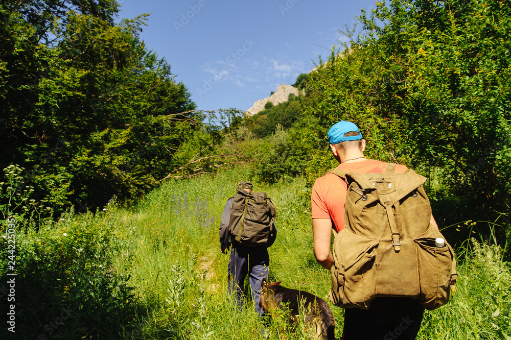 The son and father going to the mountains. Hiking. 