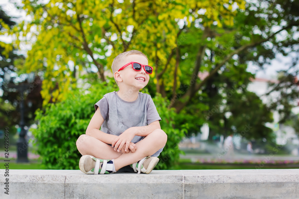 happy little boy with glasses in the park