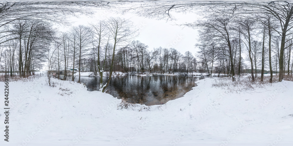 Fototapeta premium Winter full spherical seamless panorama 360 degrees angle view on road in a snowy park with gray pale sky near small river in equirectangular projection. VR AR content