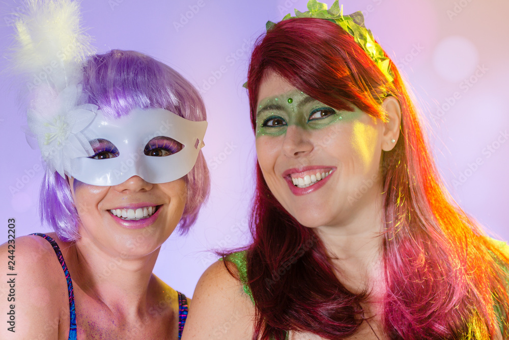 Obraz premium Carnaval Brazil. Portrait of latin women wearing purple wig and makeup mask. Color background. Masquerade concept, celebration and festival.