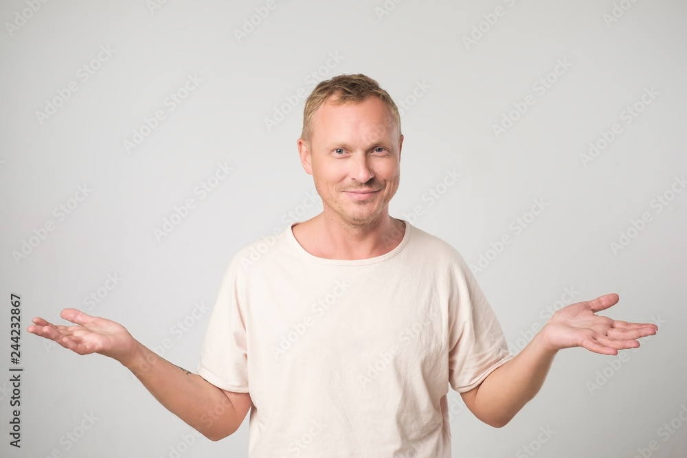 Mature man in white shirt shrugging shoulders who cares so what. Mature man in white shirt shrugging shoulders who cares so what.