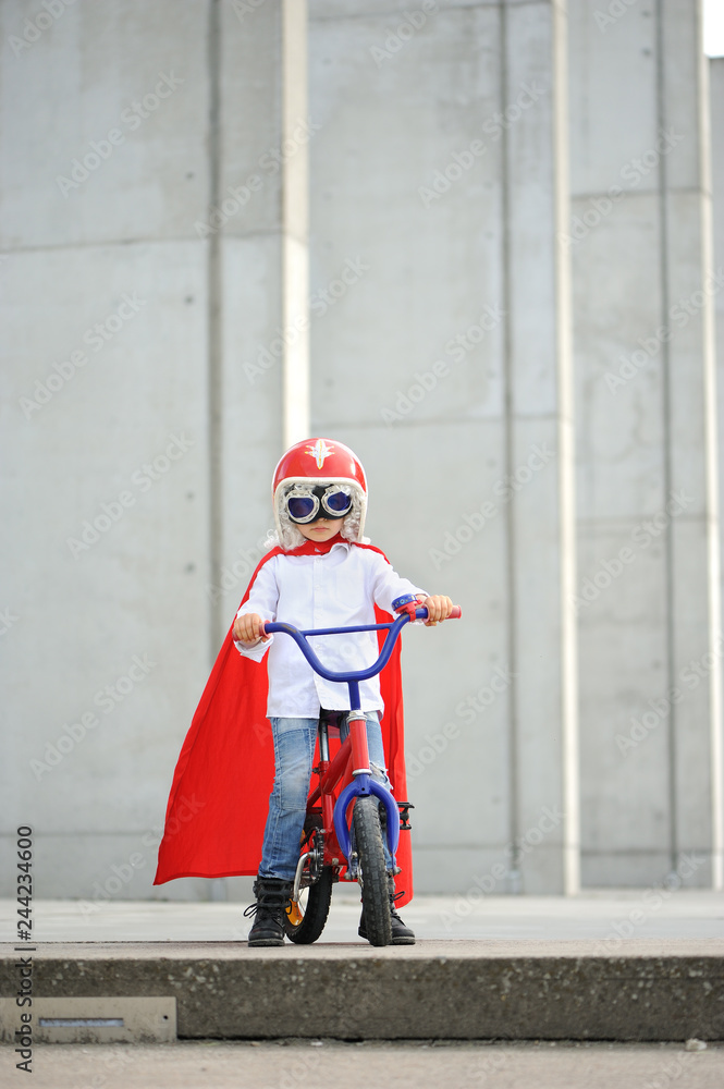 Fototapeta premium A funny, little superhero. Concept boy imagination. Happy childhood.