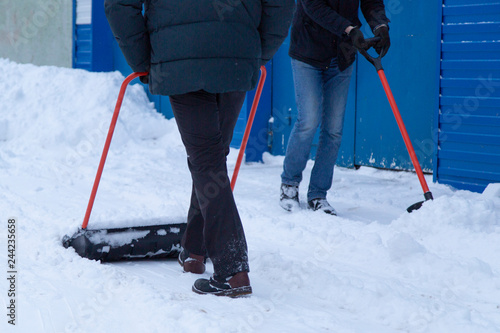 Clearing snow with a shovel in the winter on the street 