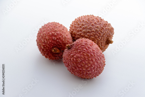 Lychee (LEE-chee; Litchi chinensis) is the sole member of the genus Litchi in the soapberry family, Sapindaceae. Three lychee is on a white background. Tropical fruit.