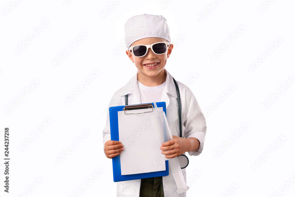 A little, smiling boy doctor in medical uniform, isolated on white, with stethoscope on the neck, reminds you about health care and healthy lifestyle. Waist up portrait, looking at camera. A little, smiling boy doctor in medical uniform, isolated on white, with stethoscope on the neck, reminds you about health care and healthy lifestyle. Waist up portrait, looking at camera.