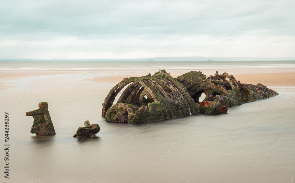 Long exposure shot in of a Midget submarine used as practice target by the RAF during WW2, and abandoned on the beach in Aberlady Bay, East Lothian. Scotland, UK