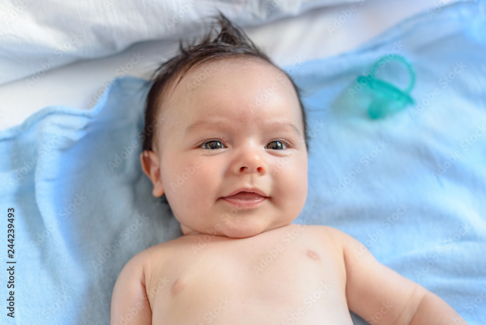 Bebé de tres meses tumbado sobre muselina azul 21