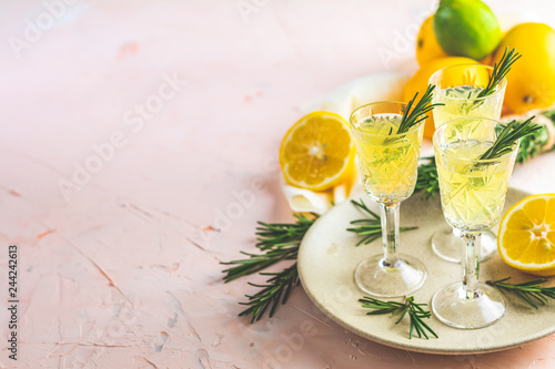 Liqueur limoncello with pieces of lemon and rosemary herb photo