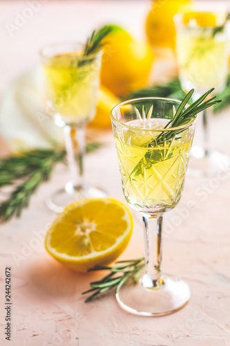 Liqueur limoncello with pieces of lemon and rosemary herb