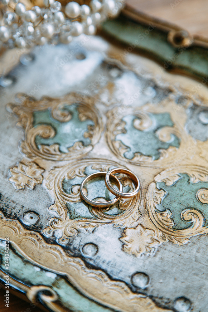 Wedding decor and details of the bride's morning. Rings on a Golden saucer, with printing. Wedding decor and details of the bride's morning. Rings on a Golden saucer, with printing.