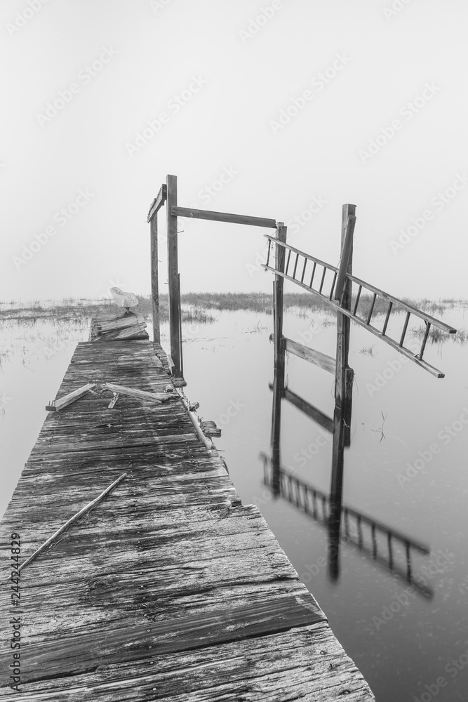 Obraz premium View on abandoned pier on a foggy morning black and white photo