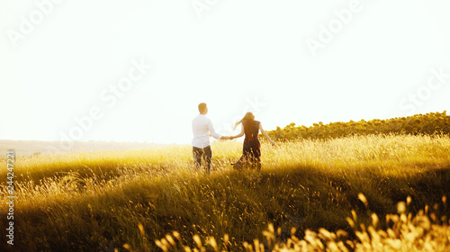 Photo of having fun handsome couple in meadow on sunset or sunrise