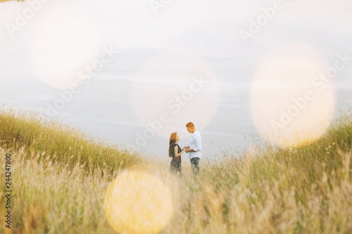 Handsome couple photo standing on the top of the hill and looking to each other