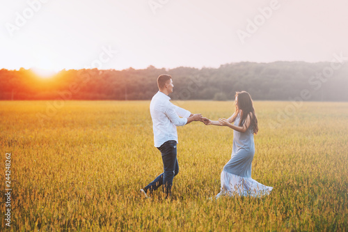 Photo of couple having fun in beautiful meadow on sunset or sunrise