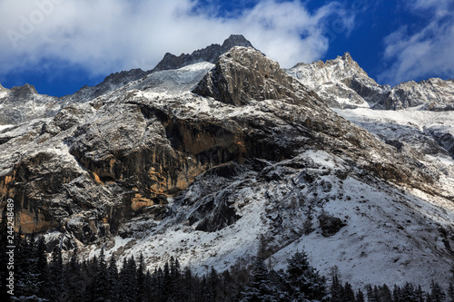 Picturesque winter scenery - Four Girls Mountain National Park in Sichuan Province, China. Shuangqiao Valley, Blue Sky, white puffy clouds, Snow Capped Mountains. Snow Covered Trees, Siguniangshan photo