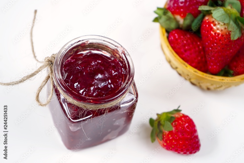 Strawberry jam in a jar on white background with fresh berries on side Strawberry jam in a jar on white background with fresh berries on side