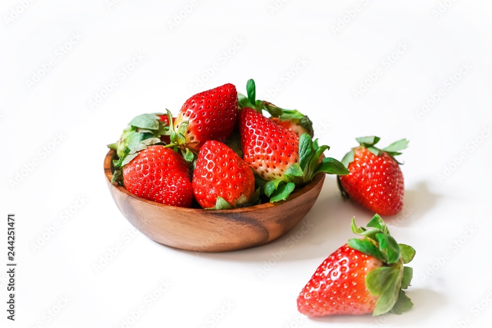 Fresh strawberries in a wooden bowl isolated on white Fresh strawberries in a wooden bowl isolated on white