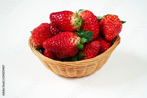 Fresh strawberries in a wooden bowl isolated on white