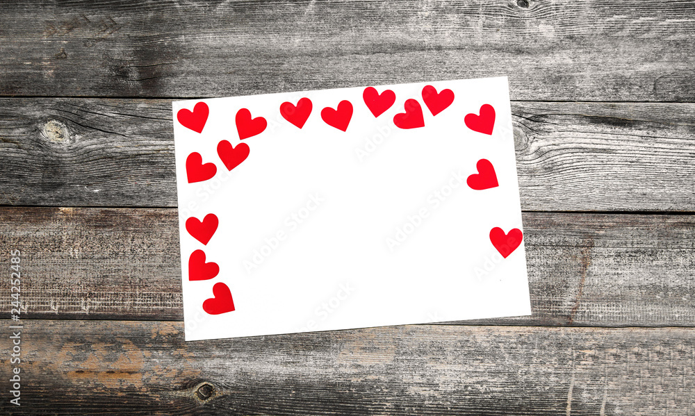 Valentine's day concept with white paper and red heart on wooden table