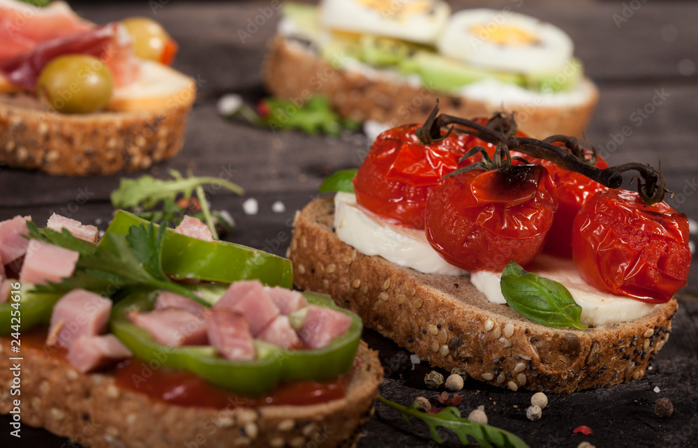 Set of different bruschettas on dark wooden table. Set of different bruschettas on dark wooden table.
