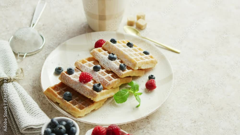 Fresh baked waffles on plate decorated with berries with cup of coffee placed near on white background Fresh baked waffles on plate decorated with berries with cup of coffee placed near on white background