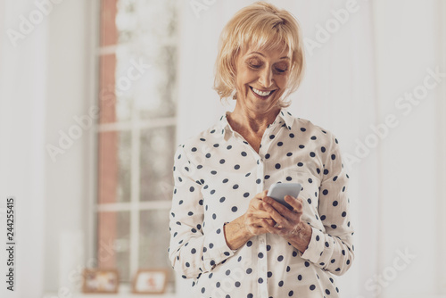 Joyful housewife typing friendly message